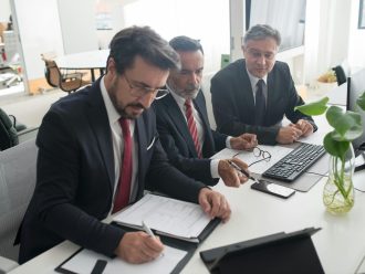 Three professionals collaborating on business plans in modern office.